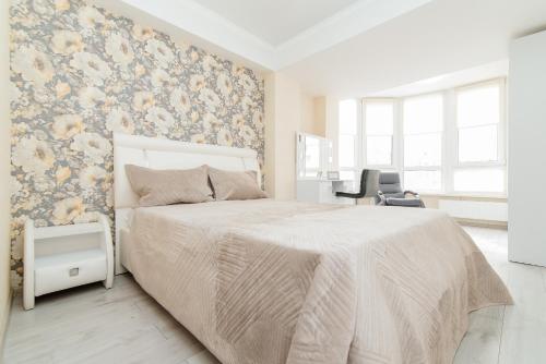 a bedroom with a bed with a floral accent wall at LuxRent in Chişinău