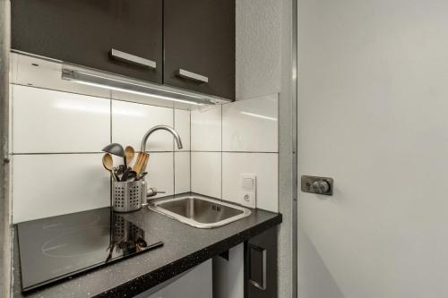 une cuisine avec un évier et un plan de travail dans l'établissement Résidence Les Glaciers - Résidence GLACIERS I & II N°412 MAE-5111, à La Plagne Tarentaise