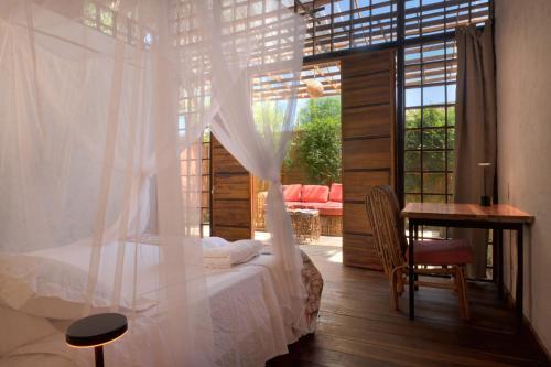 a bedroom with a bed and a table and a window at Haku hotel in Palomino