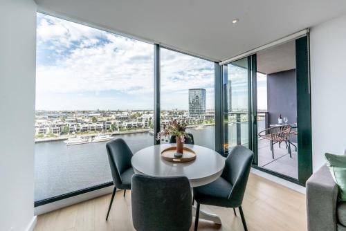 a room with a table and chairs and a large window at Melbourne Corporate Stays - Docklands Waterfront in Melbourne