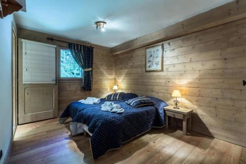 - une chambre avec un lit bleu dans un mur en bois dans l'établissement Les Chalets Du Gypse - LES CHALETS DU GYPSE C08 MAE-3791, à Saint-Martin-de-Belleville