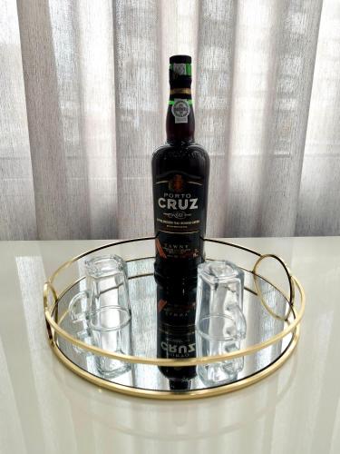 a bottle of gin and glasses on a metal tray at Douro Residence Porto Gaia in Vila Nova de Gaia