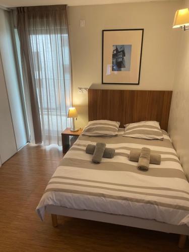 a bedroom with a large bed with two pillows on it at Studio Harmonie Confluence Lyon City et piscine chauffante in Lyon