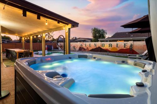 a jacuzzi tub on a patio with a table at Slide into Fun Pool Games Fire Pit Sport Court in Glendale