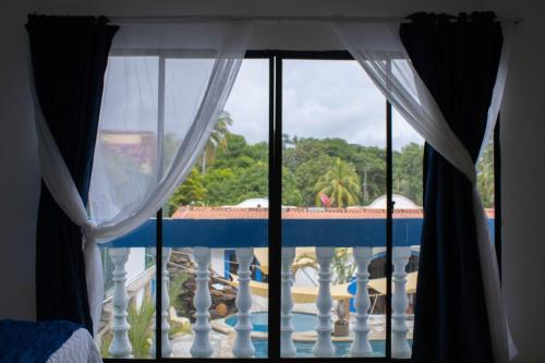 uitzicht op een zwembad vanuit een slaapkamerraam bij Casa Coral in Los Cóbanos