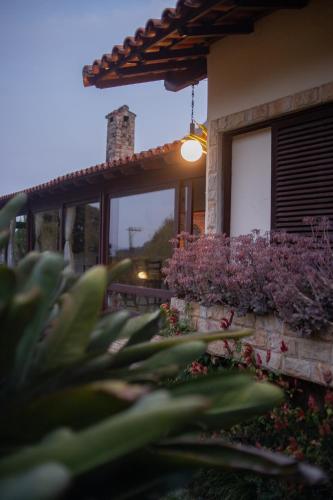 a building with a window with purple flowers on it at Recanto dos Vianas in Teresópolis