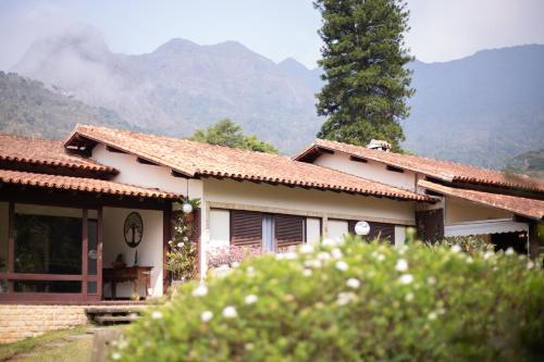 a small house with mountains in the background at Recanto dos Vianas in Teresópolis