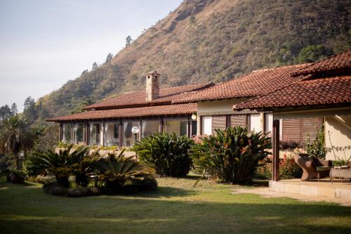 a house with a mountain in the background at Recanto dos Vianas in Teresópolis