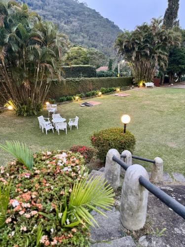 a garden with a table and chairs and flowers at Recanto dos Vianas in Teresópolis