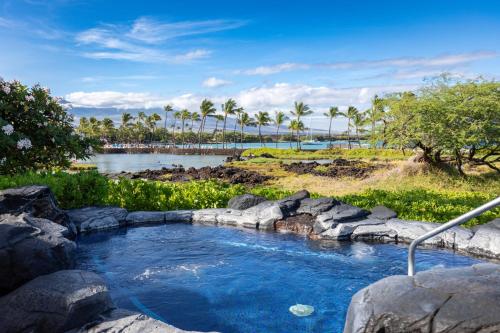 a pool of water with rocks and a river at Hilton Pool Pass Included, Kolea - Luxe Penthouse, Walk to Beach in Waikoloa