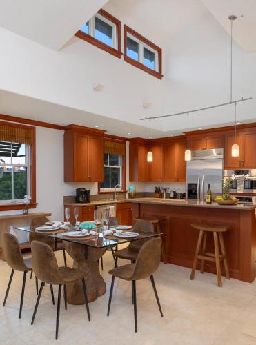 a large kitchen with a table and chairs in it at Hilton Pool Pass Included, Kolea - Luxe Penthouse, Walk to Beach in Waikoloa