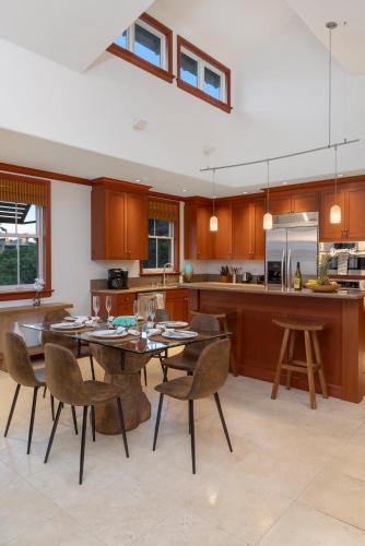 a large kitchen with a table and chairs in it at Hilton Pool Pass Included, Kolea - Luxe Penthouse, Walk to Beach in Waikoloa