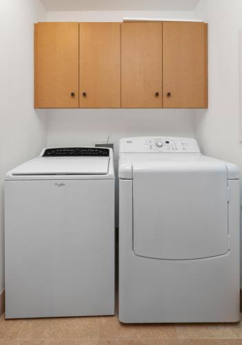 two white refrigerators in a kitchen with cabinets at Hilton Pool Pass Included, Kolea - Luxe Penthouse, Walk to Beach in Waikoloa
