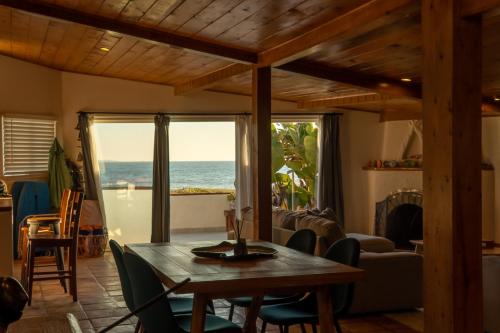 a dining room with a table and a view of the ocean at Casa Patron - Cozy fun on the beach in Ensenada