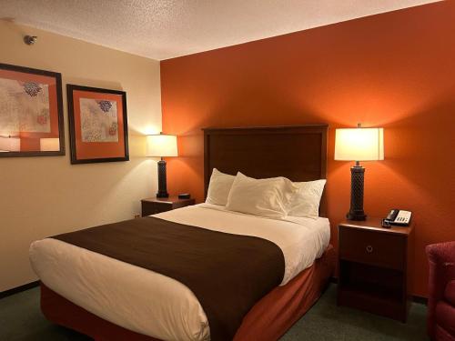 a hotel room with a large bed with two lamps at Northwoods Inn & Suites - Blackduck in Blackduck