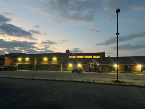 a building with cars parked in a parking lot at night at Northwoods Inn & Suites - Blackduck in Blackduck