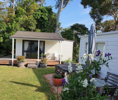 una casa con un banco y un paraguas en un patio en Vintage Christie, en Havelock North