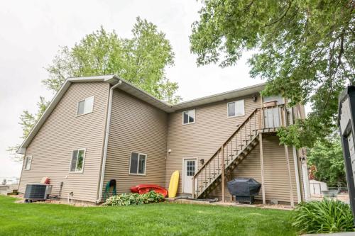 a house with a staircase in a yard at Waterfront Johnson Lake Getaway with Fire Pit! in Johnson Lake