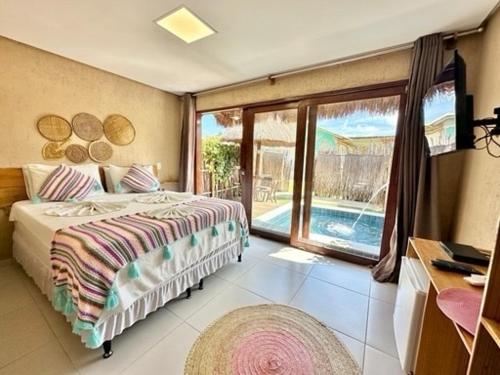 a bedroom with a bed and a large window at Chalés Milagres Beach in São Miguel dos Milagres