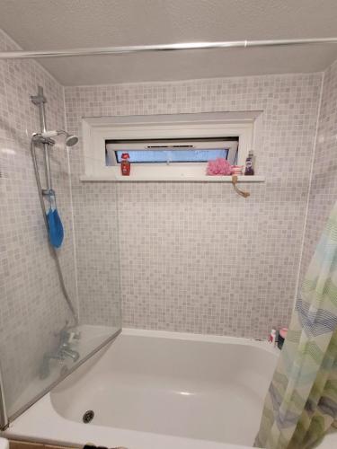 a bathroom with a bath tub and a window at egHoliday in London