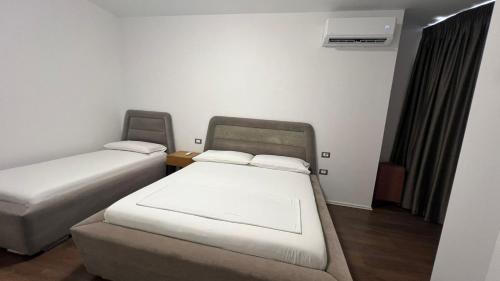 a room with two beds and a air conditioner at Skanderbeg Apartment in Tirana