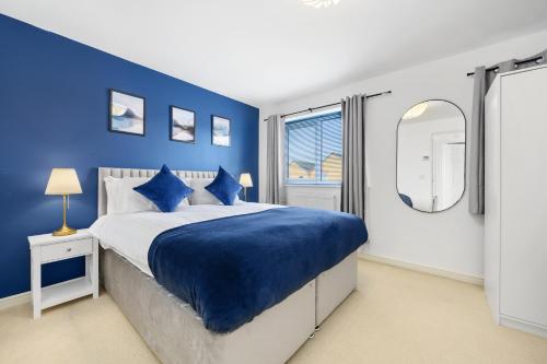 a blue bedroom with a large bed with blue walls at Superb Two Bedroom House Near Etihad & Coop Live - Free Parking in Manchester