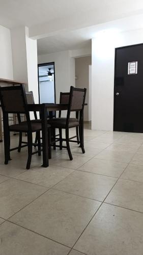 four chairs and a table in a room at Mercado 28 Residences in Cancún