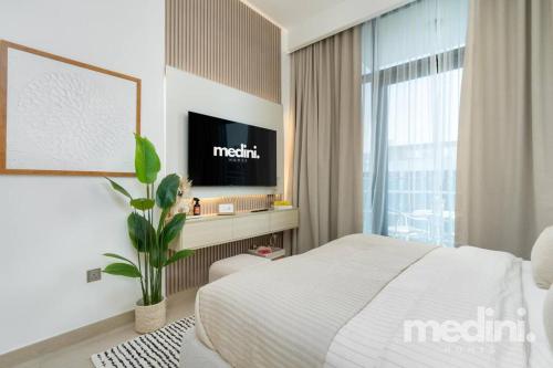 a hotel room with a bed and a tv at 12min from Burj Khalifa - Studio - Azizi Riviera in Dubai