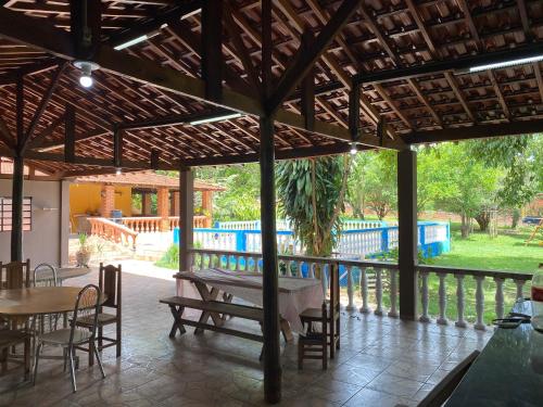 a patio with a table and chairs and a fence at Chácara linda e espaçosa in São Carlos