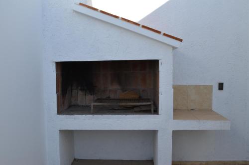 a white building with a fireplace in it at Complejo Fátima in Villa Dolores