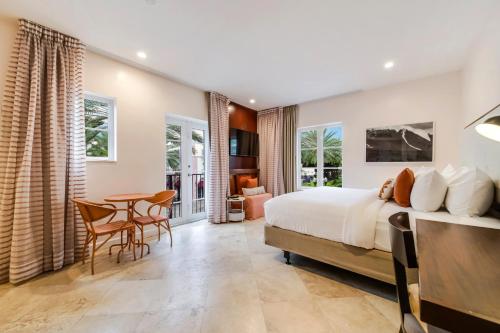 a bedroom with a bed and a table and chairs at Casa Victoria Orchid Hotel in Miami Beach