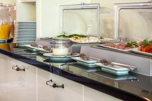 una línea de buffet con platos de comida y bebida en NAKUK Landhotel und Restaurant, en Wangerland