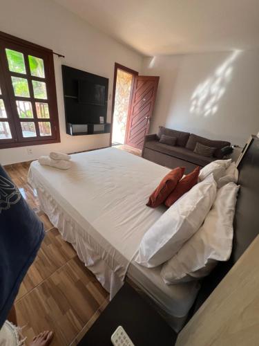 a large bed in a living room with a couch at Pipa Golfinhos Pousada in Pipa