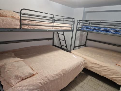 two bunk beds in a room with a bed at Villas de encanto in Vilamarxant