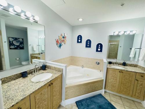a bathroom with a tub and a large mirror at Luxurious & Epic Condo in heart of Orlando in Orlando