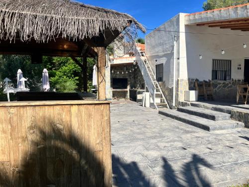 a building with a staircase and a straw roof at Villas de encanto in Vilamarxant