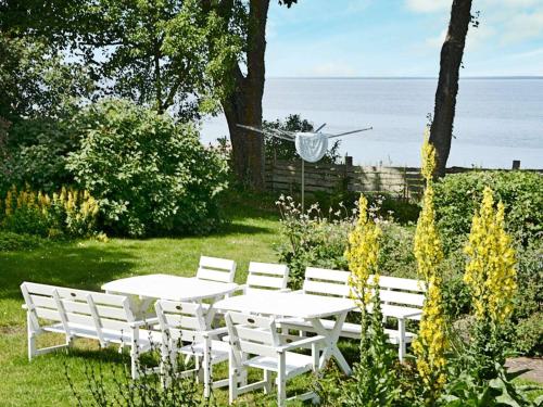 a white table and chairs with the ocean in the background at 10 person holiday home in Mörbylånga-By Traum in Mörbylånga