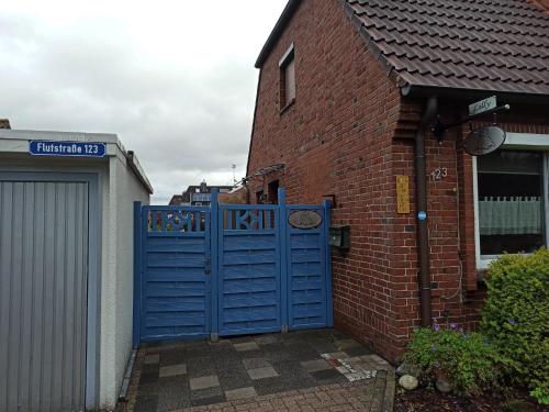 a blue gate on the side of a brick building at Seehund-Lilly in Wilhelmshaven