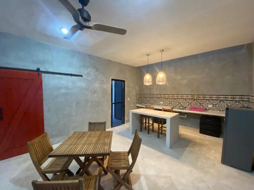 a dining room with tables and chairs and a kitchen at Casa Costa Rosa - Habitación Brisa in Yuluc