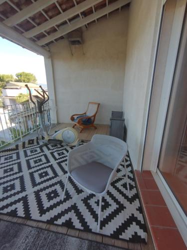 Cette chambre dispose d'un balcon avec une chaise et un tapis. dans l'établissement Luberon sud, à La Bastidonne