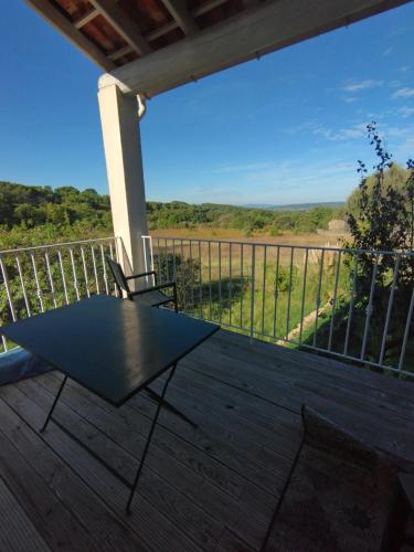 une table et des chaises noires sur une terrasse avec vue dans l'établissement Luberon sud, à La Bastidonne