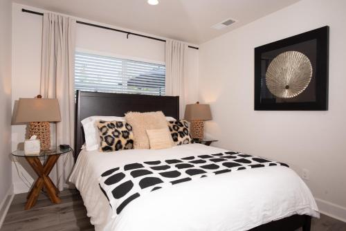 a bedroom with a black and white bed and a window at Modern 1 BR Cottage Steps 2Beach in San Diego