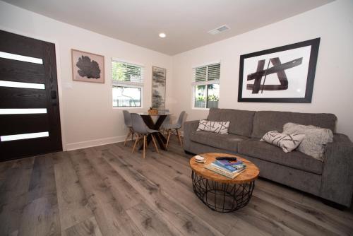 a living room with a couch and a table at Modern 1 BR Cottage Steps 2Beach in San Diego