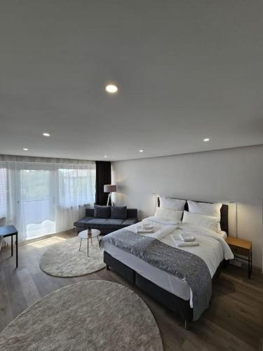 a bedroom with a large bed and a living room at White Estate IZM in Garbsen