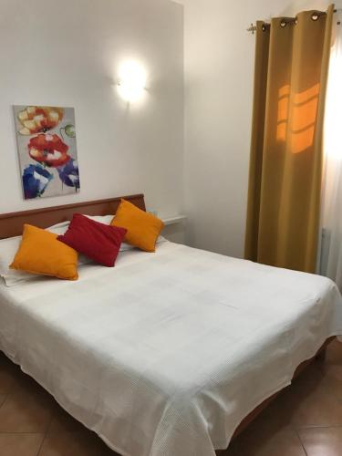a bed with four pillows on it in a room at Casa di Cristina in Fiumicino