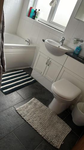 a bathroom with a toilet and a sink and a tub at Guest House in Rose Meare Gardens in Bristol