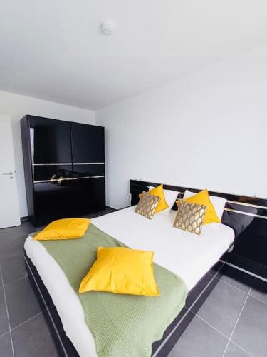 2 letti in una camera con cuscini gialli e verdi di 2 bedrooms Penthouse in Center w Terrace&Parking a Hesperange