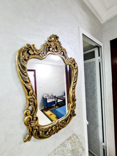 a gold mirror on a wall next to a door at Luxury Apartment Fes - Family Suites in Fès