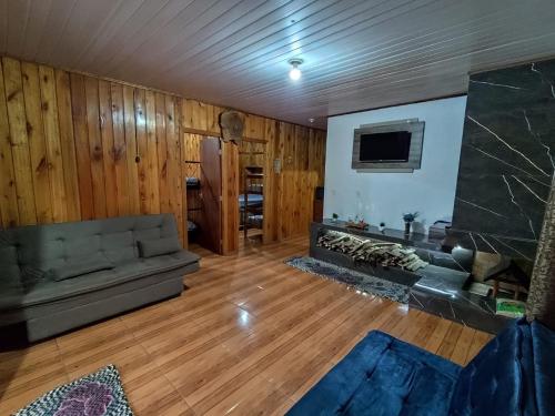a living room with a couch and a fireplace at sitio recanto feliz in Canelinha