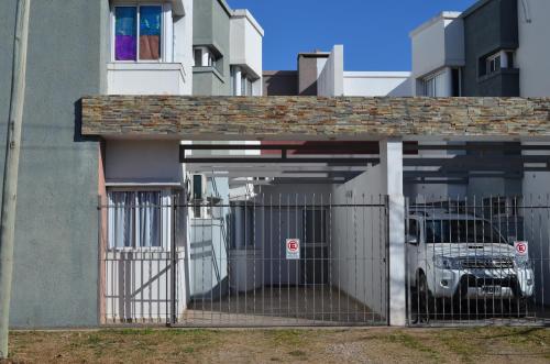 a gate in front of a building with a truck in it at Complejo Fatima in Villa Dolores